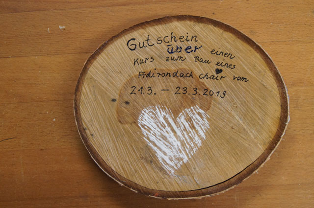 Eine Baumscheibe mit Beschriftung als Gutschein für einen Kurs in Mannes Tischlerei