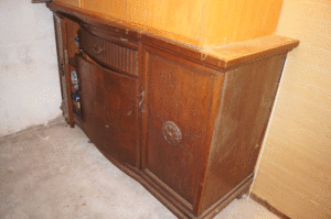 Die Anrichte steht im Keller und scheint sich vor Scham über ihr Aussehen in der Ecke zu verstecken