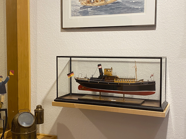 Ein mit speziellen Tablarträgern montiertes Regalbrett hält auch eine schwere Vitrine